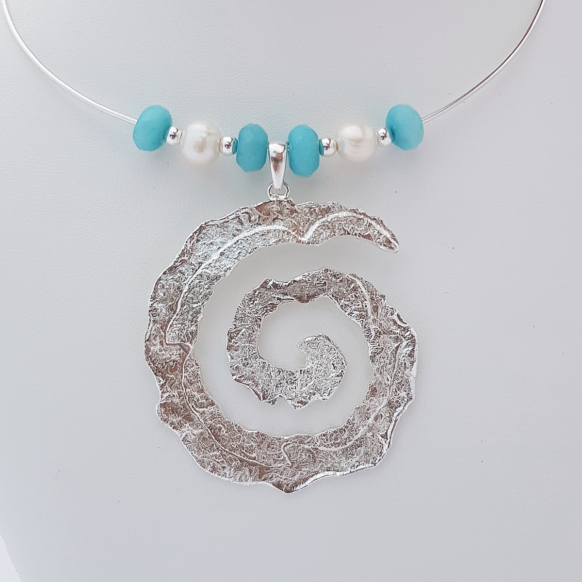 Colgante espiral de plata artesanal con ágata azul turquesa y perlas. Joyas Siliva.